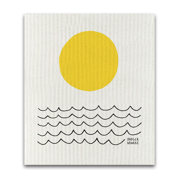 a swedish sponge cloth featuring a minimalist illustration of a yellow sun and black wavy lines representing the sea