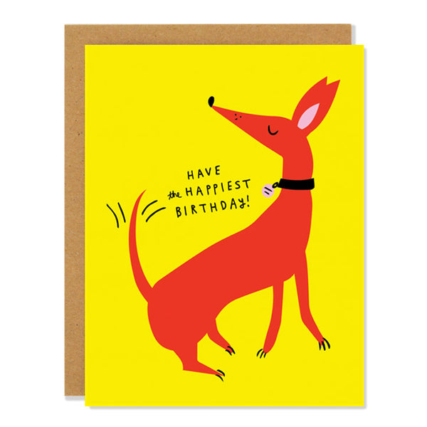 a birthday greeting card featuring an illustration of a happy red dog wagging it's tail in excitement, with text reading "Have the Happiest Birthday" on a yellow background