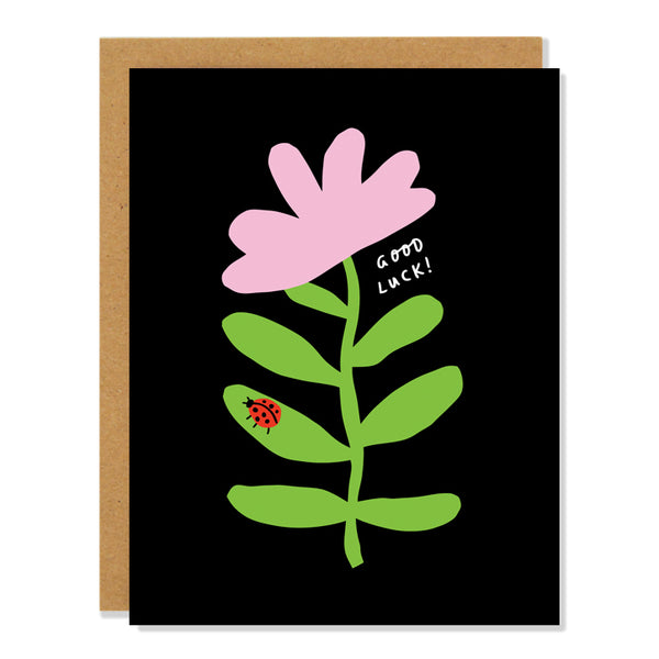 a good luck greeting card with an illustration of a small red ladybug on the leaf of a flower, on a black background. the text reads: Good Luck! 
