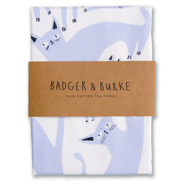 a tea towel that features an assortment of silly lavender cats, spread across the entire tea towel.