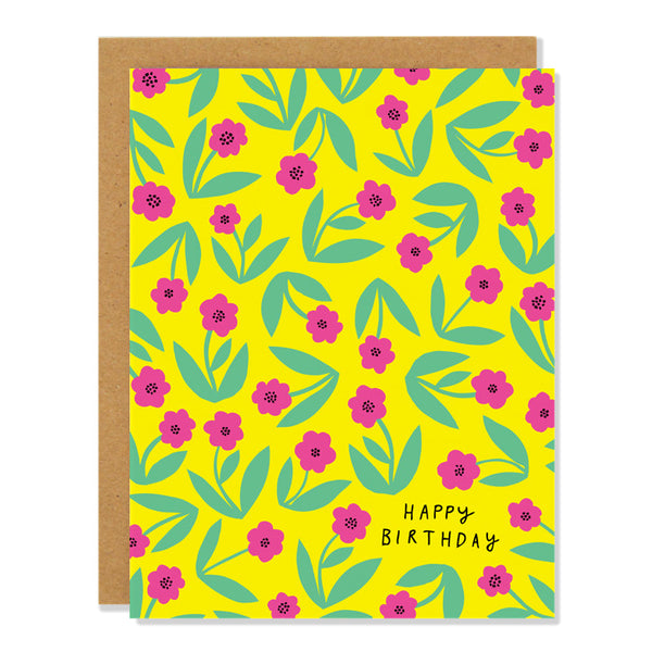 A birthday greeting card featuring a pattern of little pink flowers with green stems on a bright yellow background, with text reading "Happy Birthday". 