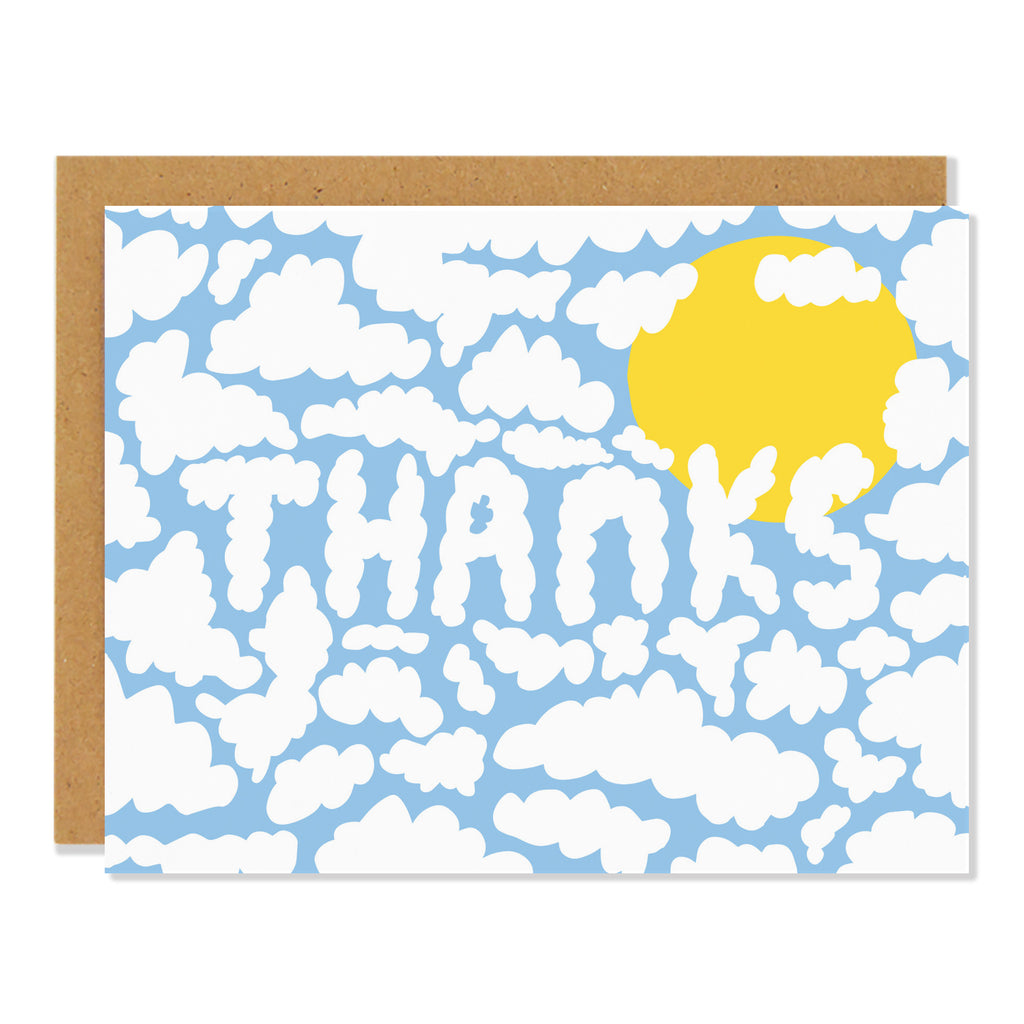 A blue greeting card with a pattern of white clouds and a yellow sun, with the word "THANKS" written in white cloud-like letters in the center. The card has a brown kraft paper envelope.