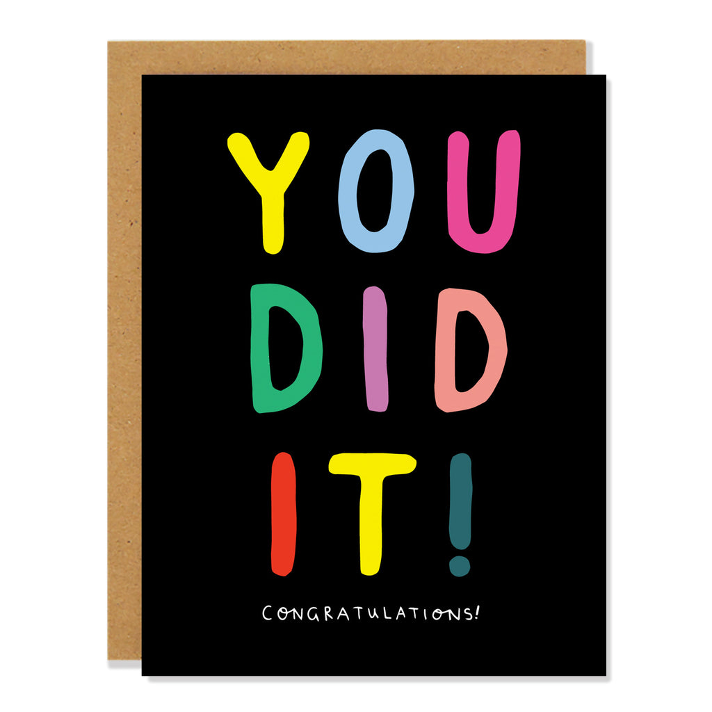 A congratulatory card with "YOU DID IT!" written in colorful block letters on a black background with the word "CONGRATULATIONS!" written in small white letters below.
