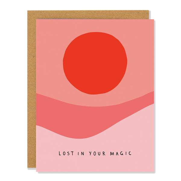a love and friendship greeting card featuring an abstract illustration of a desert landscape in warm red and orange tones with the text "lost in your magic" at the bottom