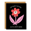 a sympathy greeting card with an illustration of a red and pink flower with a sweet face and outspread leaves. Text reads: "I'm here for you with open arms"