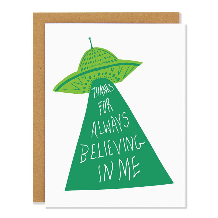 a thank you greeting card featuring an illustration of a UFO with a large beam of green light shining down. Within the beam reads the text: "Thanks for always believing in me" 