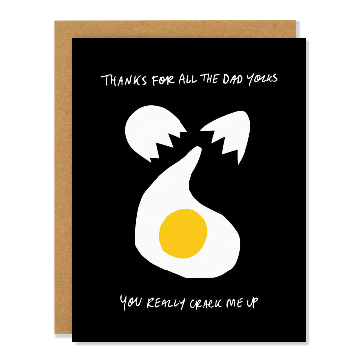 A greeting card with a black background and a stylized illustration of a cracked egg with a yellow yolk. The text on the card reads "Thanks for all the dad yolks. You really crack me up."