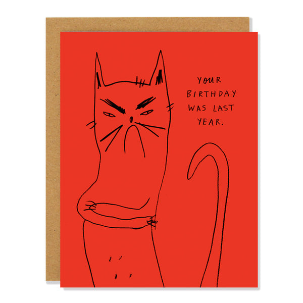 A red greeting card with a black line drawing of a grumpy cat and the text "Your birthday was last year."