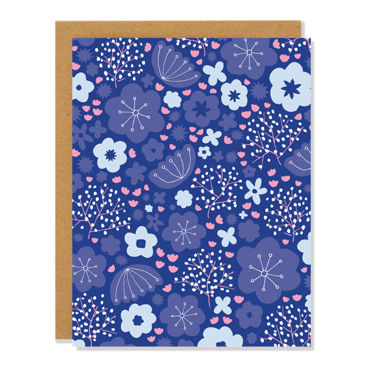 A greeting card with a dark blue background covered in a pattern of various shades of blue and pink flowers, leaves, and abstract botanical designs.