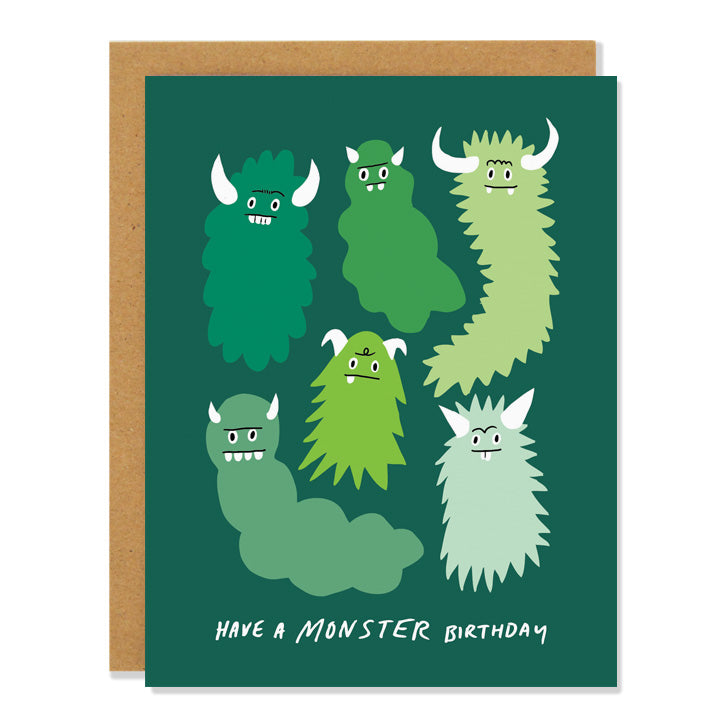 a birthday greeting card featuring illustrations of six cute little monsters with horns and goofy faces, in shades of green, against a darker green background. Bottom text reads: Have a monster Birthday
